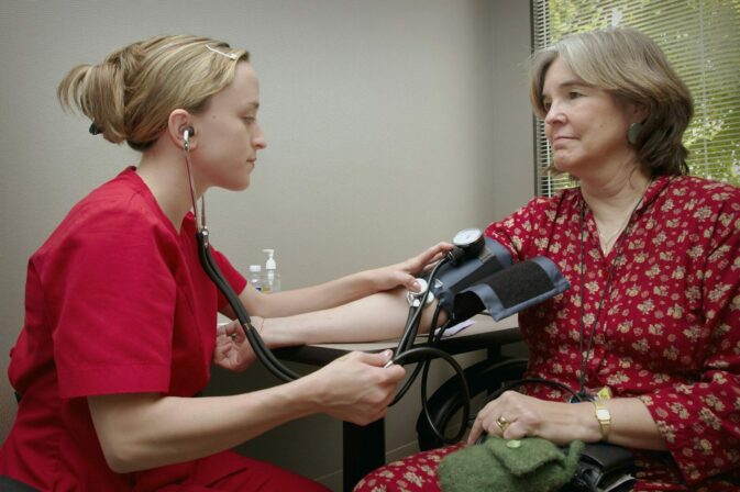 Photo by CDC a woman with a stethoscope listening to a patient