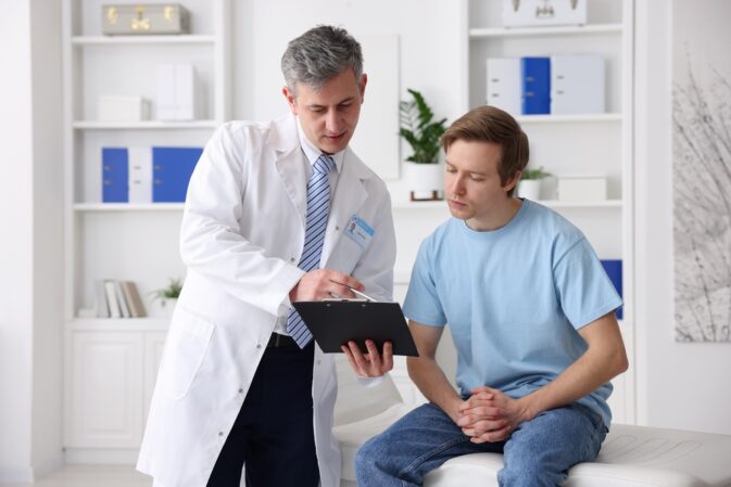 Urologist,Showing,Clipboard,To,Patient,In,Clinic
