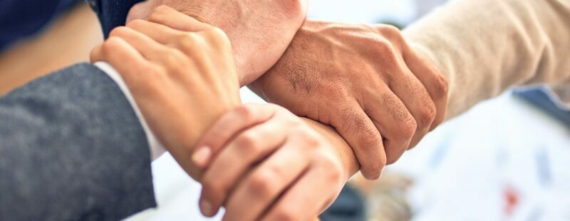 Photo by krakenimages team members gripping wrists in unity gesture