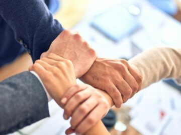 Photo by krakenimages team members gripping wrists in unity gesture